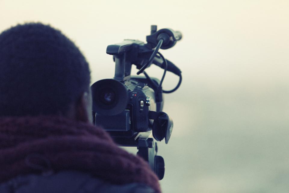 Videographer filming with a professional camera, representing video content production
