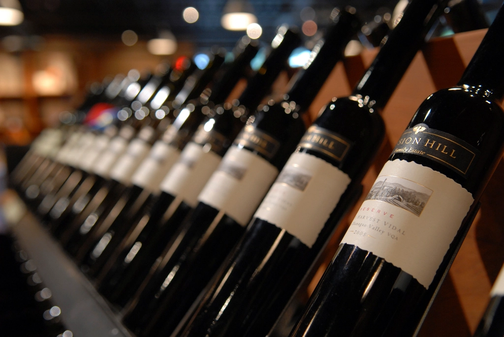 Liquor store shelves stocked with bottles and price tags