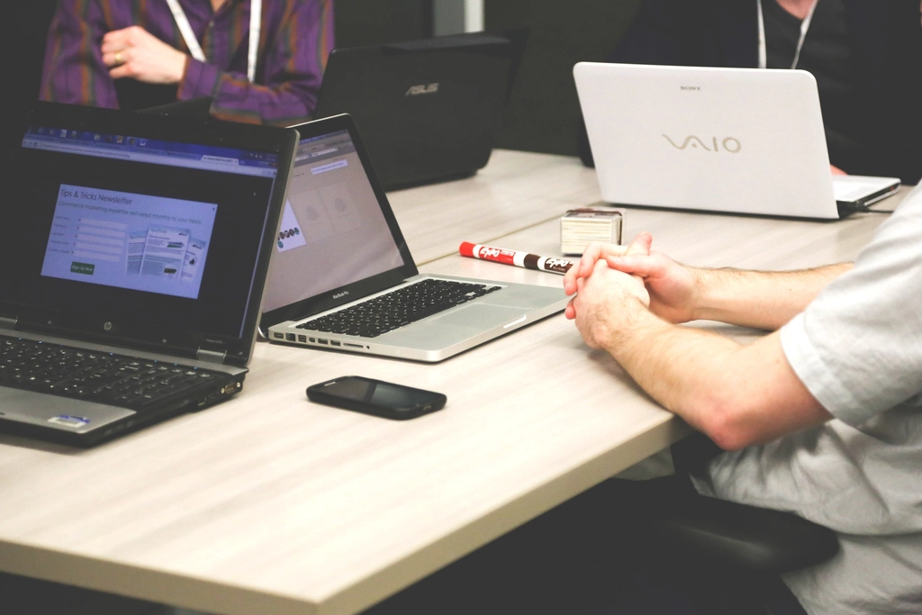 Employees with laptops seated together during an office meeting
