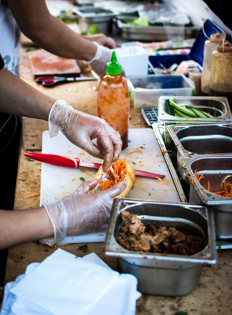 Chef plating an order in a busy commercial restaurant kitchen
